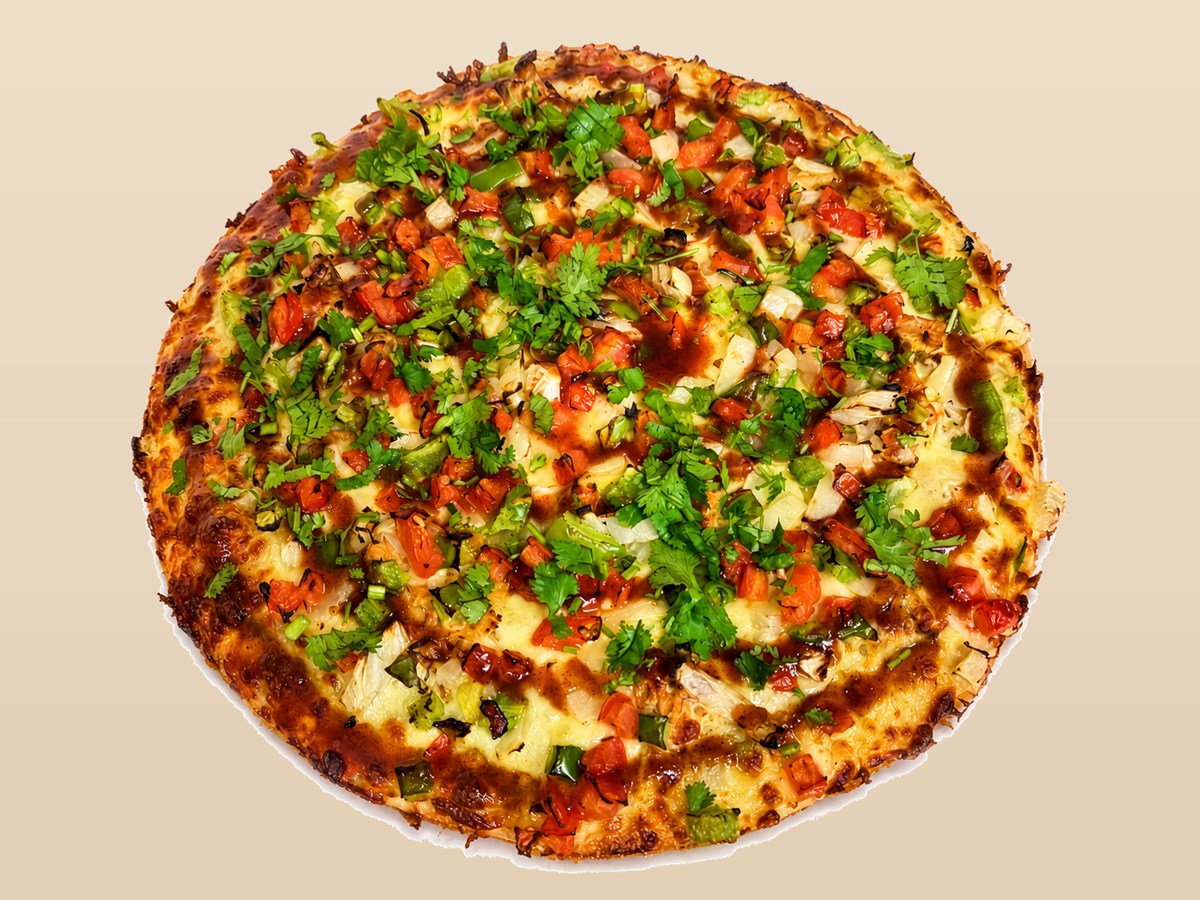 Departure Bay Pizza Samosa Pizza with samosa pieces, vegetables, cilantro and signature chutney drizzle.